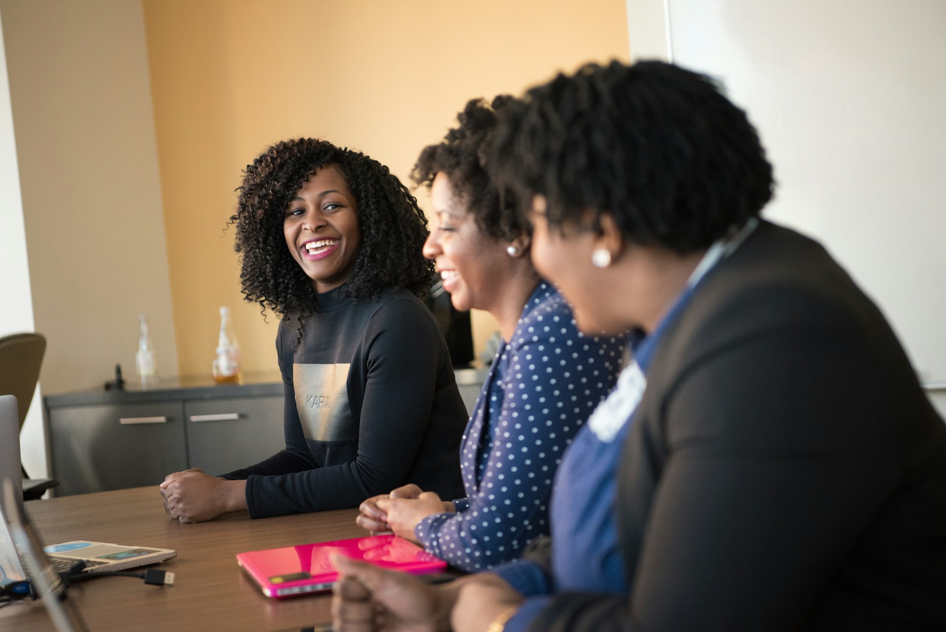 Three nonprofit staff members smiling together at a conference table